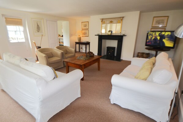 Ground floor: Spacious sitting room with electric wood burner and comfortable sofas