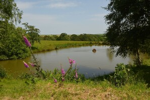 Guests can enjoy wonderful views across rolling countryside from their own private lake with ornamental fish and seating