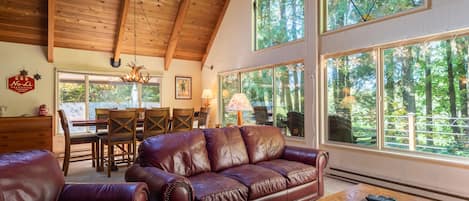 Living Room - Living room with large windows and views of the wooded area and golf course located behind the home. There is a pellet stove and TV in this room as well.