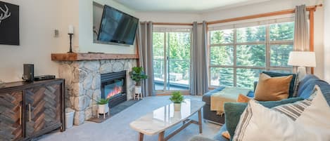 Living Room - Enjoy the beautiful forest scenery, cozy up in front of the fireplace, enjoy Netflix or cable on the large wall-mounted TV.