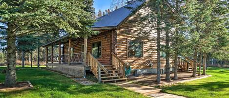 The cabin is nestled between towering pine trees!