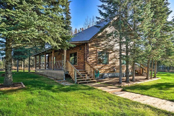 The cabin is nestled between towering pine trees!