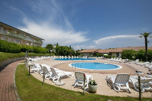 Der Pool mit Sonnenliegen.