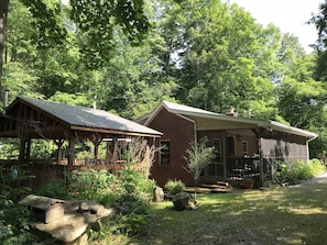 Main cabin w/ outdoor fireplace, table for 6, picnic table & fire pit in yard.