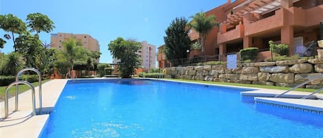 Inviting community swimming pool surrounded by lovely gardens