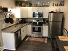 Fully stocked kitchen with granite countertops, fridge, oven, microwave, and DW