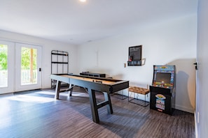 Open game room with shuffleboard and Street Fighter Arcade Cabinet