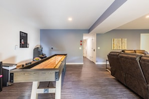 Lower level fun living space with 9' shuffleboard table, arcade game, and books