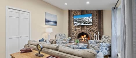 Living Room: "Cozy sofa set by stoned fireplace, overlooking through the window."