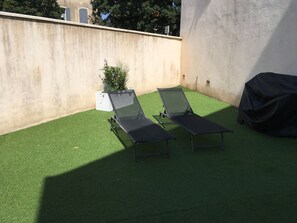 Cour fermée avec barbecue et bain de soleil