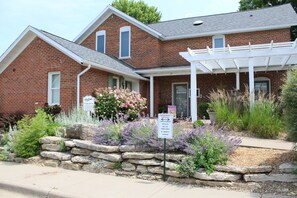 You are welcomed by a spacious patio surrounded by beautiful landscaping. 