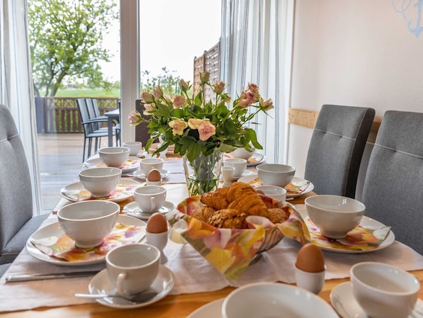 Essplatz für 8 Personen mit Blick auf die Terrasse und angrenzenden Garten mit Weitblick auf die Felder