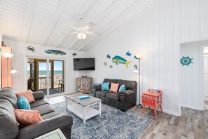 Open floor plan with bright beachy decor and slider with entry into screen room.