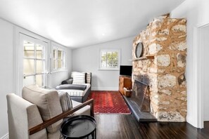 Living room with open fireplace, Smart TV and games.