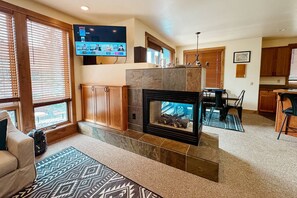 Comfortable open concept main living area with gas fireplace and smart TV