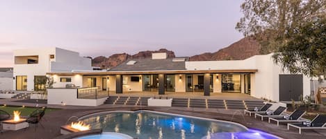 Entertainment paradise awaits in the expansive backyard patio. With three fire features, a heated pool with a Baja lounge, a hot tub, BBQ, bocce ball court, putt-putt green, ping pong table, and water features and mountain views.