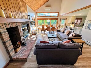 Step into luxury with this cozy yet expansive living room, featuring plush seating and a wood-burning fireplace,