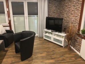 Das Wohnzimmer mit Flachbildschirm TV und Soundsystem. 