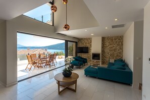 Stylish living room opens towards a terrace with an outdoor dining table