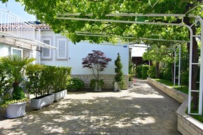 Il cortile recintato con giardino impreziosito da fiori e piante.