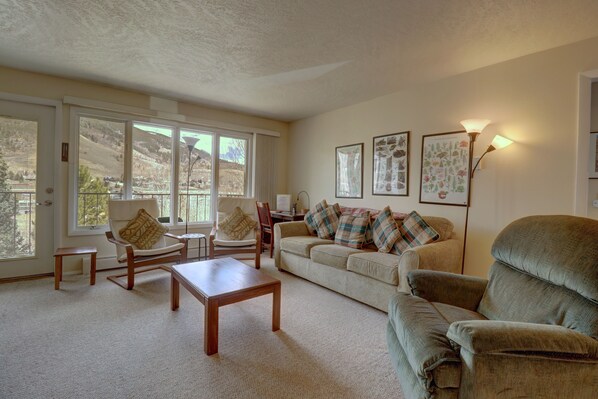 Cozy open concept living room with multiple seating options.