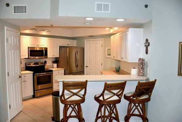 Full kitchen stocked with dishes and cooking supplies.