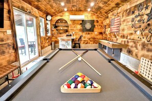 Gameroom with bar, dartboard, shuffleboard, arcade games, TV, and pool table 