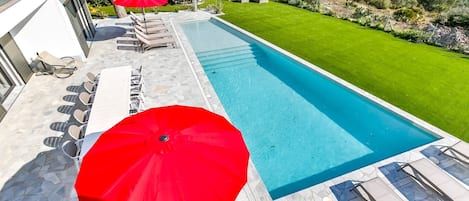 Fantastischer türkisfarbener Swimmingpool mit spektakulärem Blick über die umliegende Landschaft und auf das tiefblaue Mittelmeer.