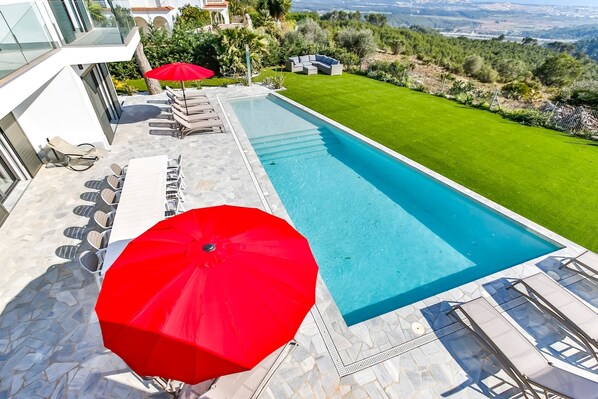 Fantastischer türkisfarbener Swimmingpool mit spektakulärem Blick über die umliegende Landschaft und auf das tiefblaue Mittelmeer.