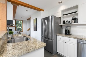 Gourmet kitchen features granite countertops and contemporary stainless steel appliances