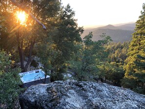 The hot tub sits at the edge of the property overlooking the national forest.