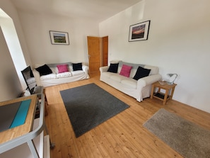 The lounge area with two 3-seater sofas and television. 