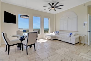 The open living area is elegantly decorated in a timeless design, creating a gorgeous backdrop for the stunning view of the bay and Gulf.