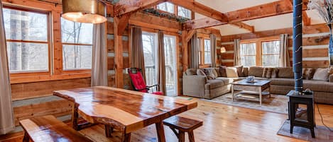 Open and bright great room with lots of light and windows and big log beams.