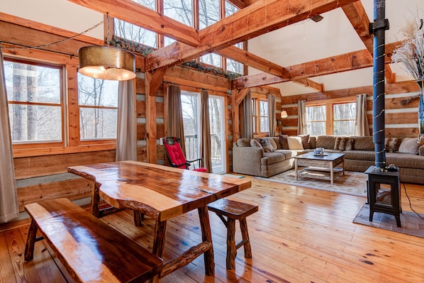 Open and bright great room with lots of light and windows and big log beams.