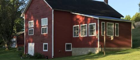 Beautiful lawn surrounds the carriage house in the summer.