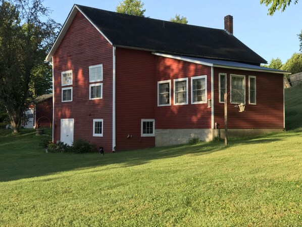 Beautiful lawn surrounds the carriage house in the summer.