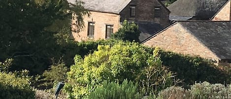 A view of the Farmhouse from the top of the site near the tennis court