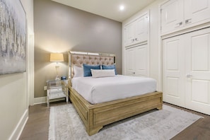 Spacious master bedroom featuring a king size bed with an ensuite bathroom and designer built in closets. The bedroom is equipped with a night stand, a lamp, hangers, luggage racks, alarm clock, white noise machine and a 50'' Samsung Smart 4K TV that allows for streaming from your favorite apps, along with the DIRECTV Entertainment.