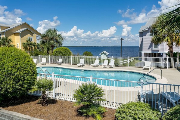 Large community pool with chairs and gorgeous views of the bay