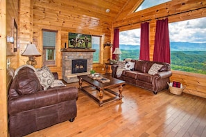 Comfortable living room with sofas, TV, and electric fireplace