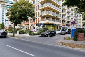 A photo of the apartment building taken from the street, showcasing its urban surroundings and modern design.