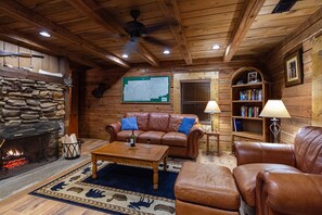 living room has real leather sofa next to a hand built stone wood burning fireplace