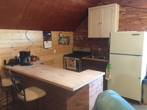 Kitchen overlooks the living room with bar seating.