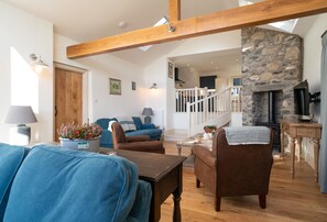 Split level ground floor: Sitting room with steps leading up to kitchen and wood burning stove