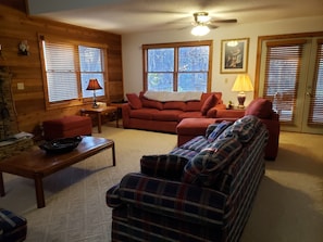 Open living room has vaulted ceiling, ceiling fan and connectes to sunroom.