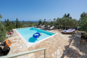 Pool with wooden sunbeds and umbrellas