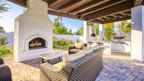 Gorgeous outdoor fireplace & kitchen w/ lounge seating, grill, pizza oven, & TV.