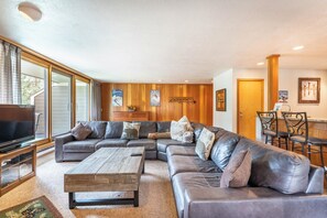 Living area featuring flat screen TV, large sectional, wood-burning fireplace and access to the private balcony.