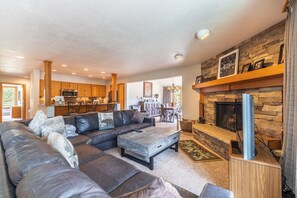 Living area featuring flat screen TV, large sectional, wood-burning fireplace and access to the private balcony.